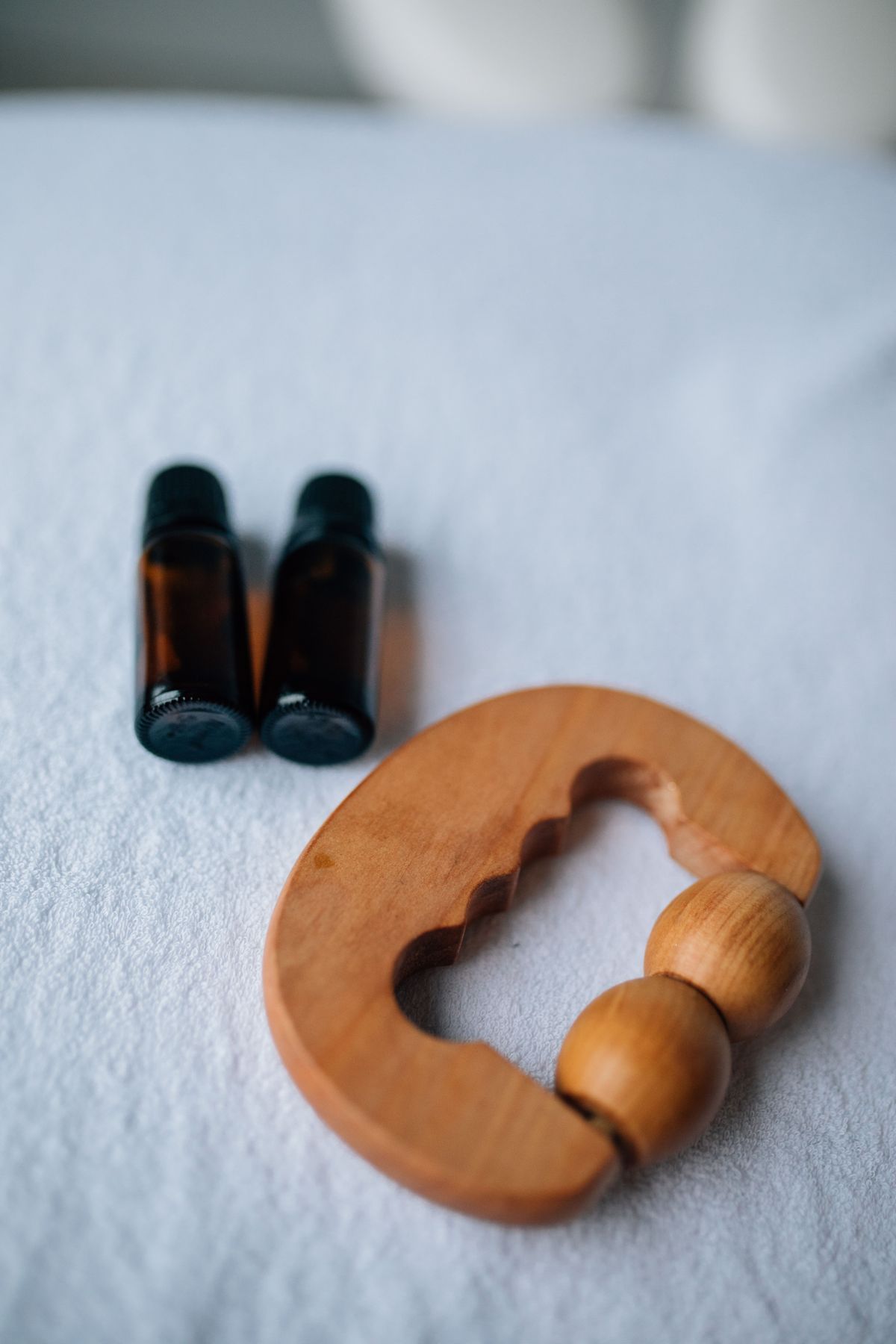 Essential oils and a wooden massage tool prepared for treatment